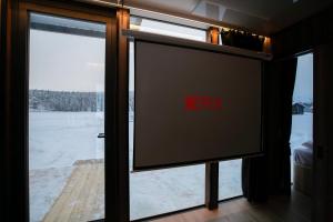 a television in front of a window with the word horror at Sonka Resort Mirror House with Lake View in Rovaniemi