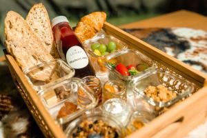 a box of food with a bottle of wine and bread at Sonka Resort Mirror House with Lake View in Rovaniemi