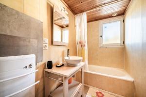 a small bathroom with a sink and a tub at Chalet Phidel - 11 personnes in Bernex +28 photos