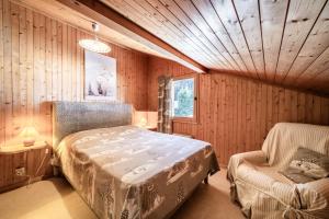 a bedroom with a bed and a chair in a room at Chalet Phidel - 11 personnes in Bernex