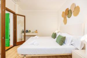 a bedroom with a white bed and a mirror at Hostal Boutique Canyamel in Canyamel