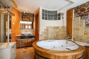 a large bathroom with a large wooden tub at Aguas del Sella - jacuzzi in Precendi +17 photos