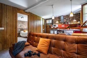 a living room with a brown leather couch at Aguas del Sella - jacuzzi in Precendi