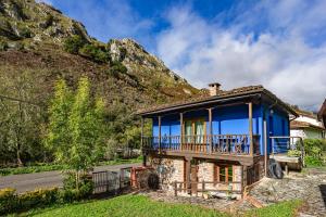 a house with a balcony on the side of a mountain at Aguas del Sella - jacuzzi in Precendi