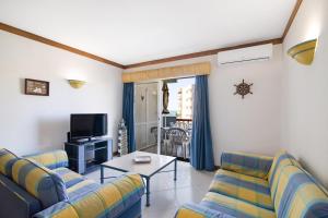 a living room with two couches and a tv at T2 com piscina centro Vilamoura in Vilamoura