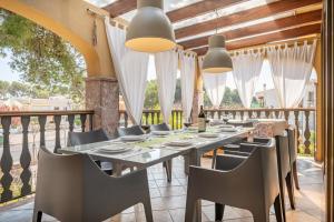 a dining room with a table and chairs on a balcony at Ca Na Kika in Alcudia