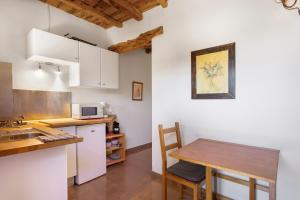 a kitchen with a wooden table and a small kitchen with white cabinets at Can Mussenya 1 in Illes Balears +8 photos