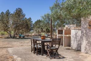 a table with chairs and a laptop on it at Can Mussenya 1 in Illes Balears