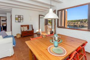 a dining room with a wooden table and a view of the ocean at Vacaciones en Cala Morell in Cala Morell