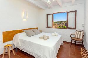 a bedroom with a bed with a window and a chair at Vacaciones en Cala Morell in Cala Morell +20 photos