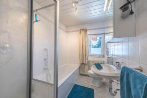 a bathroom with a tub and a toilet and a sink at Ferienwohnung Selina in Taching am See +16 photos