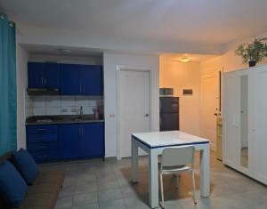 a kitchen with blue cabinets and a table with a chair at beautiful vacation Sol Caribe in Punta Cana