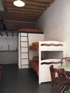 a room with three bunk beds and a table and a tableablishthritisthritisthritis at Maison St Ringo cozy apartment in Lyon