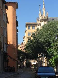 a car parked on a city street with a church at Maison St Ringo cozy apartment in Lyon