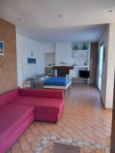 a living room with a pink couch and a bedroom at Villetta G in Senigallia