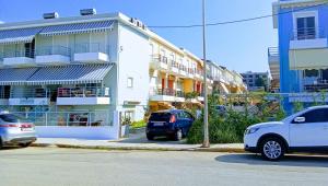 two cars parked in a parking lot next to a building at EFFIE'S VACATION by the sea in Kanali