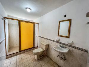 ein Badezimmer mit Toilette, Waschbecken und Spiegel in der Unterkunft Cabañas Lupita 31 in Mazamitla + 15 Fotos