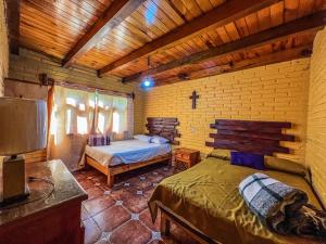 ein Schlafzimmer mit zwei Betten in einer Holzhütte in der Unterkunft Cabañas Lupita 31 in Mazamitla