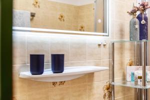 a bathroom with two blue cups on a shelf at Aschaubichl - Wohnung Alpenrose in Grainau +17 photos