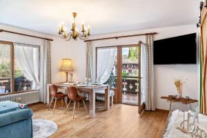 a living room with a table and chairs and a couch at Aschaubichl - Wohnung Alpenrose in Grainau