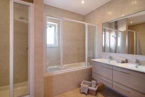 a bathroom with a tub and a sink and a shower at Casa Tulipas in Loulé +19 photos