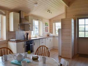 a kitchen with a table and chairs in a room at Skylark Lodge in Dumfries