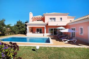 a villa with a swimming pool in front of a house at Casa Tulipas in Loulé