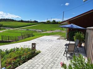 a patio with an umbrella and a chair and flowers at Ferienwohnung Pusteblume in Neukirch