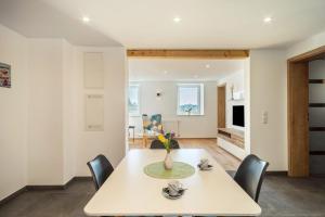 a dining room and living room with a table and chairs at Ferienwohnung Pusteblume in Neukirch