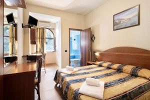 a hotel room with a bed and a desk at Appartamento Monolocale Moneglia 24 in Moneglia
