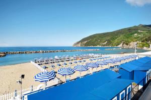 a bunch of blue and white umbrellas on a beach at Appartamento Monolocale Moneglia 24 in Moneglia