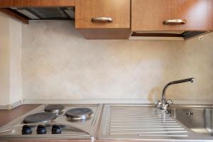 a kitchen counter with a sink and a stove at Appartamento Monolocale Moneglia 24 in Moneglia +14 photos