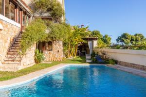 a swimming pool in a yard next to a building at Villa Relax en Benidorm in Salto de Agua
