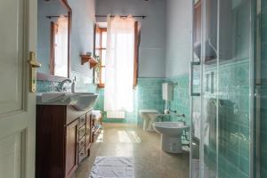 a blue bathroom with a toilet and a sink at Appartamento Giglio in Riotorto +17 photos