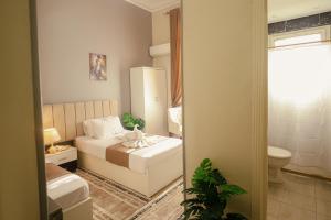 a small bedroom with a bed and a mirror at Downtown Antique Hotel in Cairo