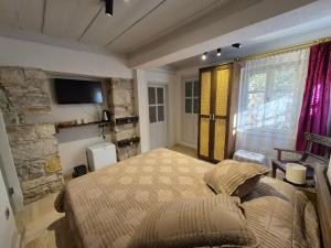 a bedroom with a bed and a tv on a wall at Kavcıoğlu Rooms in Urla