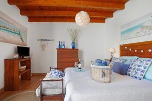 a bedroom with a bed with a wooden headboard at Vista Tostón in El Cotillo