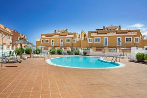 a swimming pool in a courtyard in front of a building at Apartamento 104 in Caleta De Fuste