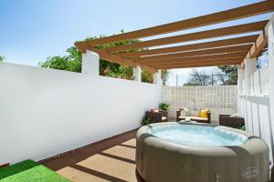 a hot tub on a patio with a pergola at Apartamento 104 in Caleta De Fuste