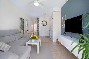 a living room with a couch and a tv at Apartamento 104 in Caleta De Fuste