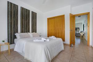a bedroom with a white bed with towels on it at Apartamento 104 in Caleta De Fuste +24 photos