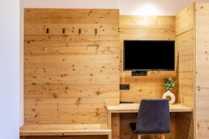 a room with a desk and a television on a wall at Zu Grof Morgenrot in Castelrotto