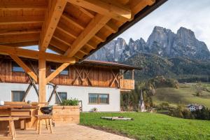 a wooden house with mountains in the background at Zu Grof Morgenrot in Castelrotto