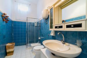 a blue tiled bathroom with a sink and a toilet at Villetta a Torre Lapillo in Torre Lapillo +19 photos