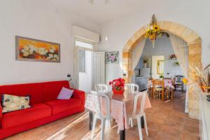 a living room with a red couch and a table at Villetta a Torre Lapillo in Torre Lapillo