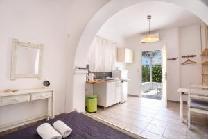 a kitchen with an archway and a table and a counter at Green Retreats 2 Paros in Isterni