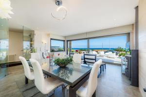 a dining room with a table and white chairs at Bohemi in Son Serra de Marina