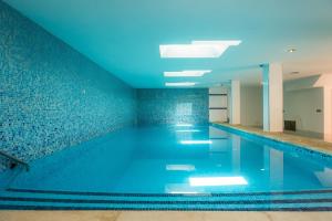a swimming pool with blue lighting in a building at Bohemi in Son Serra de Marina