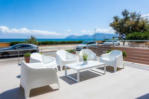 a group of white chairs and a table on a patio at Bohemi in Son Serra de Marina
