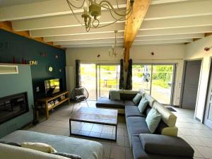 a living room with two couches and a table at Les Prairies du Val d'Amboise Grand Gite 15 pers avec piscine - PMR in Noizay